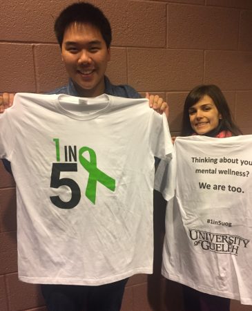 Students holding up shirts with 1 in 5 logo