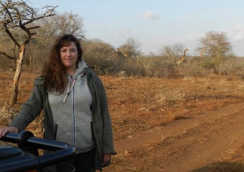 Prof Laura Graham on a game reserve with giraffes in the background