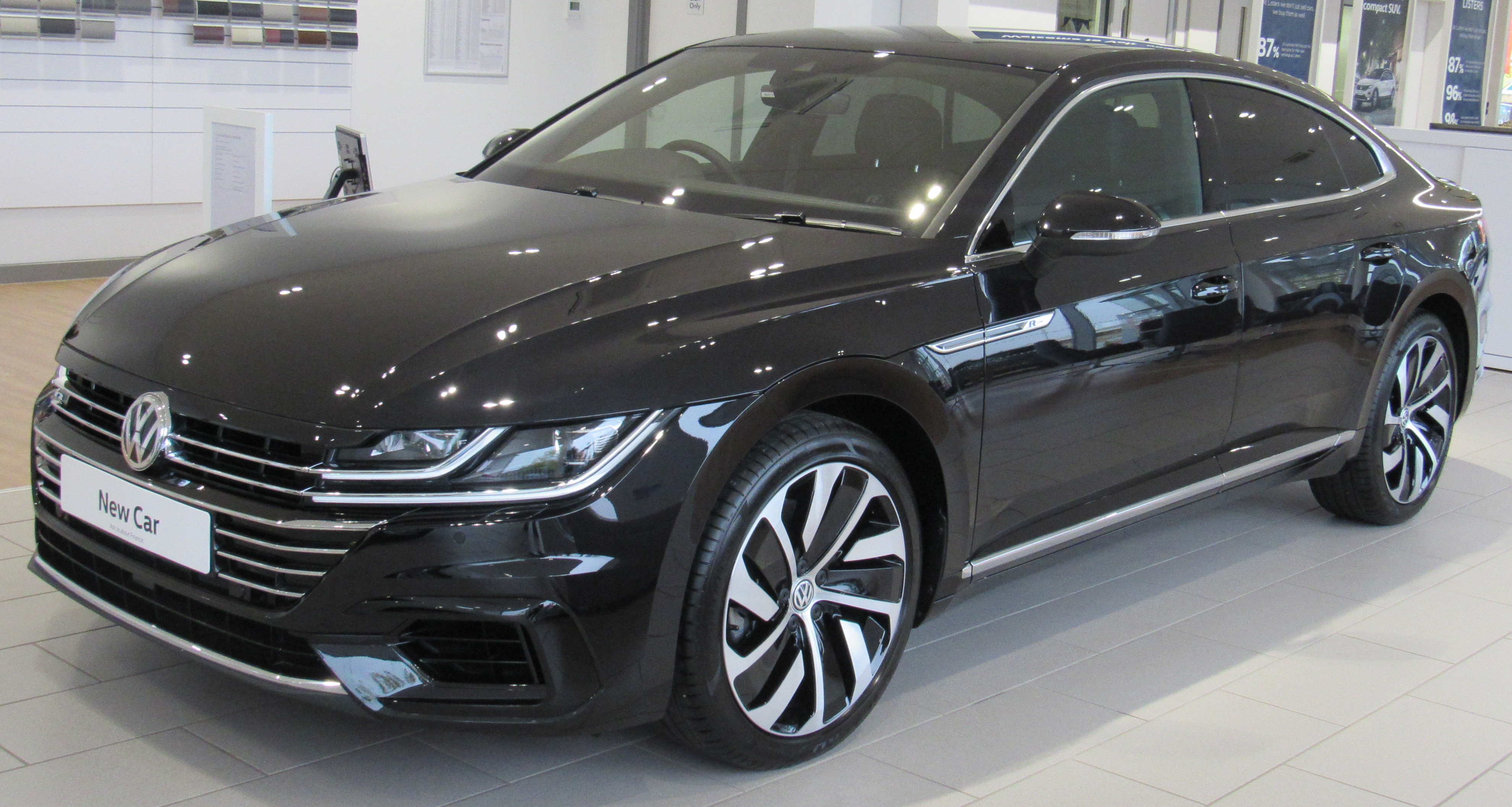 Volkswagen sedan, black, in an auto sales showroom