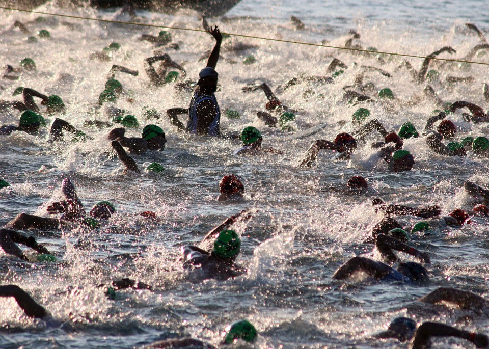 triathletes swimming in a group, lots of splashing water 