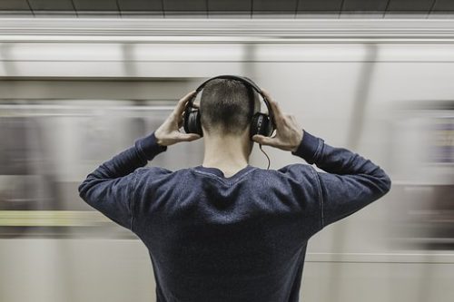 photo of man with headphones on from the back