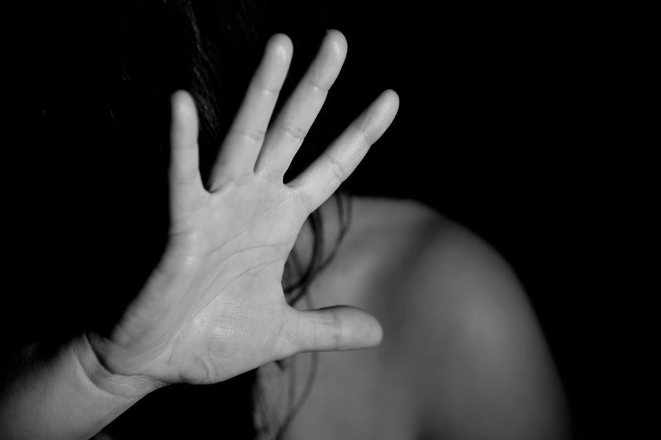 image of a woman holding her hand up to shield her face