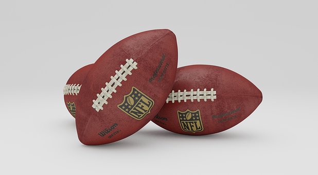 photo of three NFL footballs leaning against one another