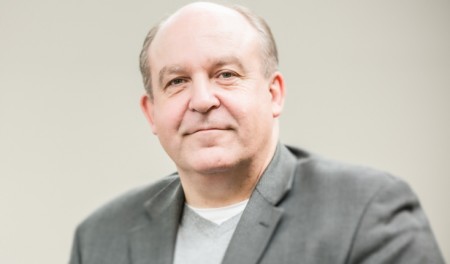 Smiling man, balding.