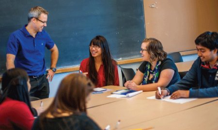 Smiling professor talking with students