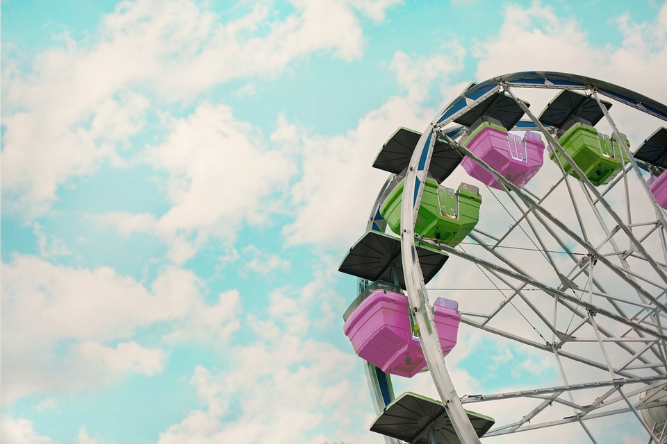 ferris wheel - close up of seats against blue sky dotted with clouds