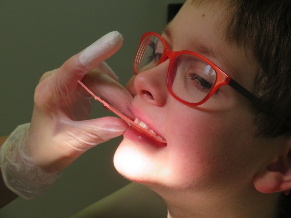 child biting down on dental impression plate