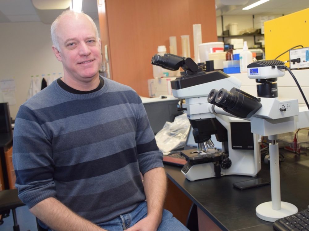 Professor Geoffrey Wood with microscopes