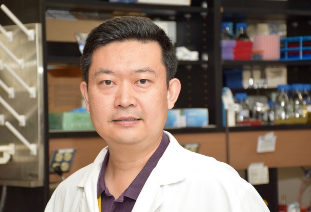 Prof. Wei Zhang in lab coat inside his laboratory