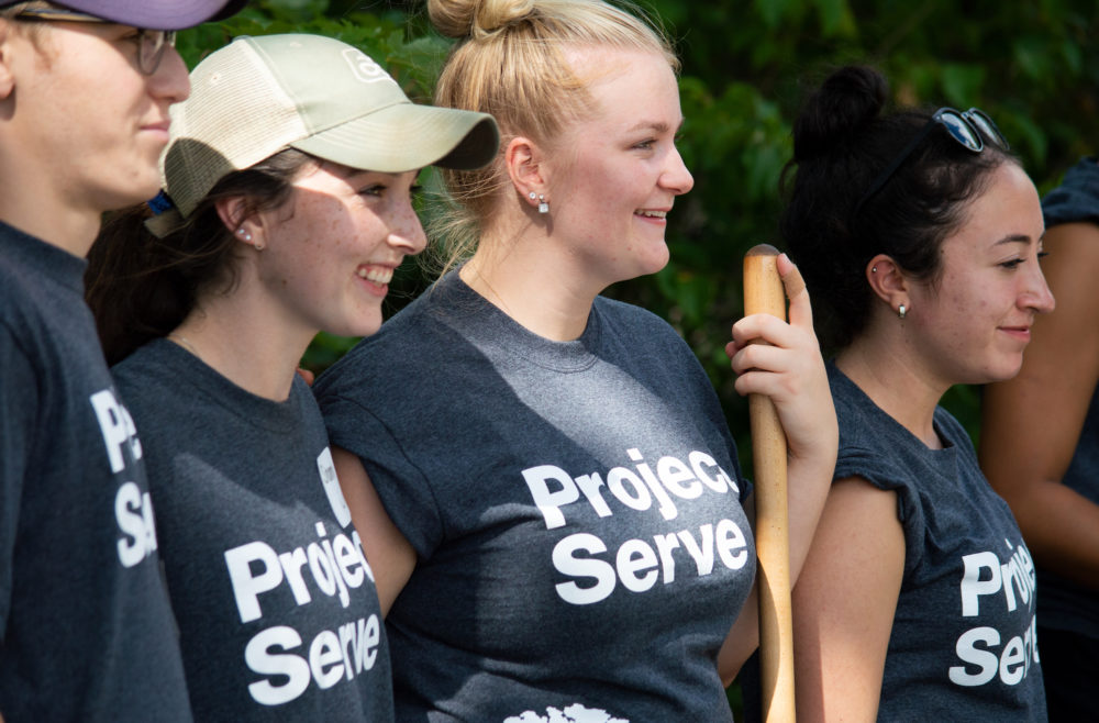 Four volunteers in Project Serve Day t-shirts are shown in this photo.