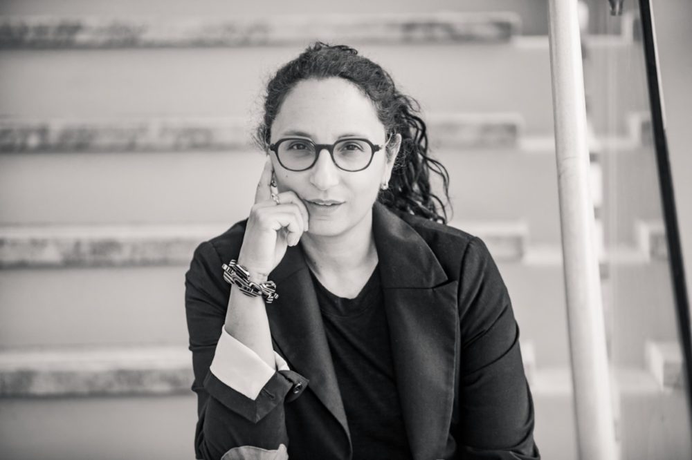 Female professor in glasses sitting on staircase