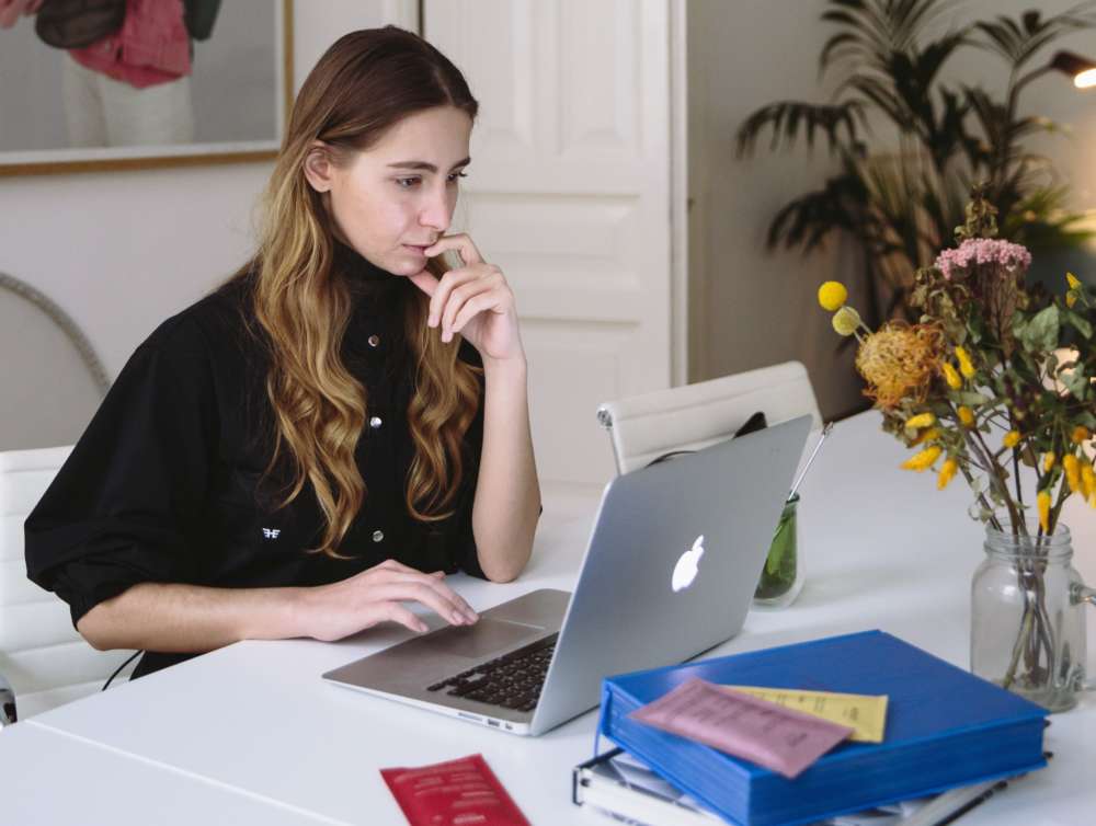 A young woman works at a laptop