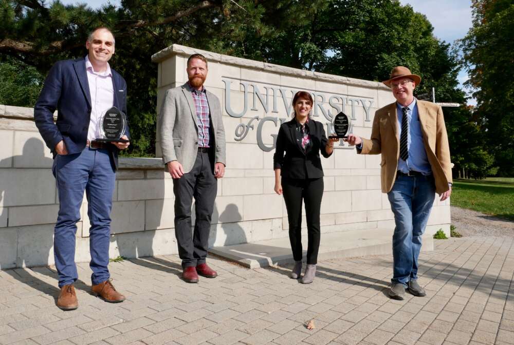 Three university researchers and an official at university entrance