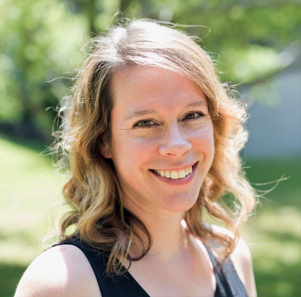 Prof. Meghan McMurtry smiles against a summer lawn