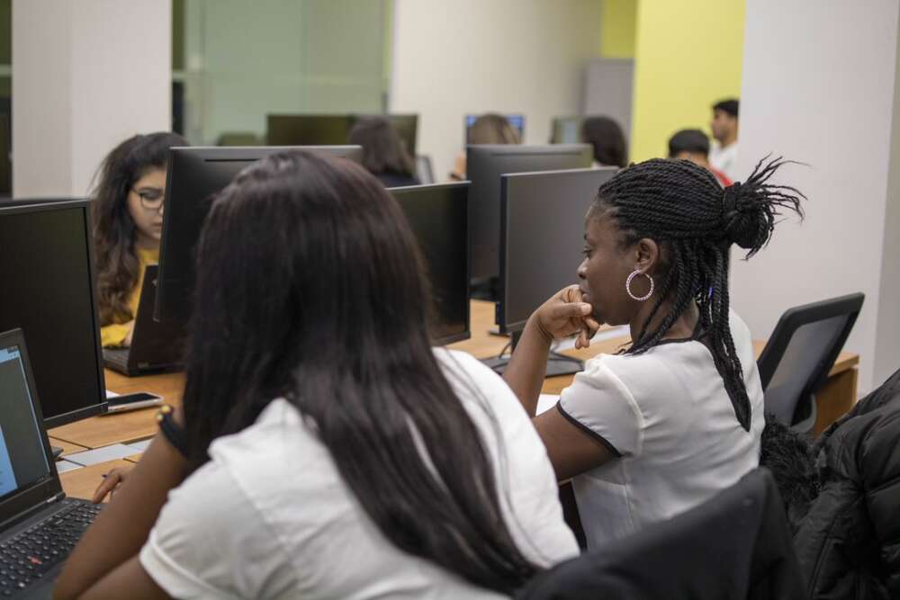 two students facing computer screens in a classroom