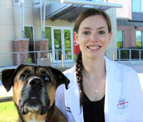 A photo of Dr. Caitlin Grant and a dog before the OVC Health Sciences Centre