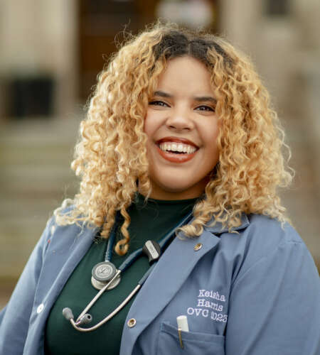 OVC veterinary student Keisha Harris with blood curly hair and stethoscope