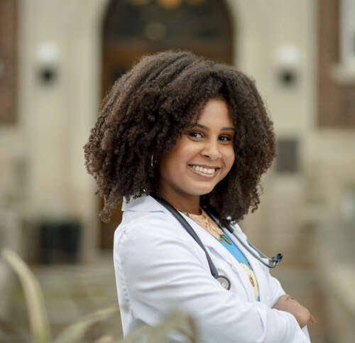 Black female OVC student with big smile, wearing stethoscope