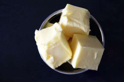 Three cubes of butter sit in a bowl.