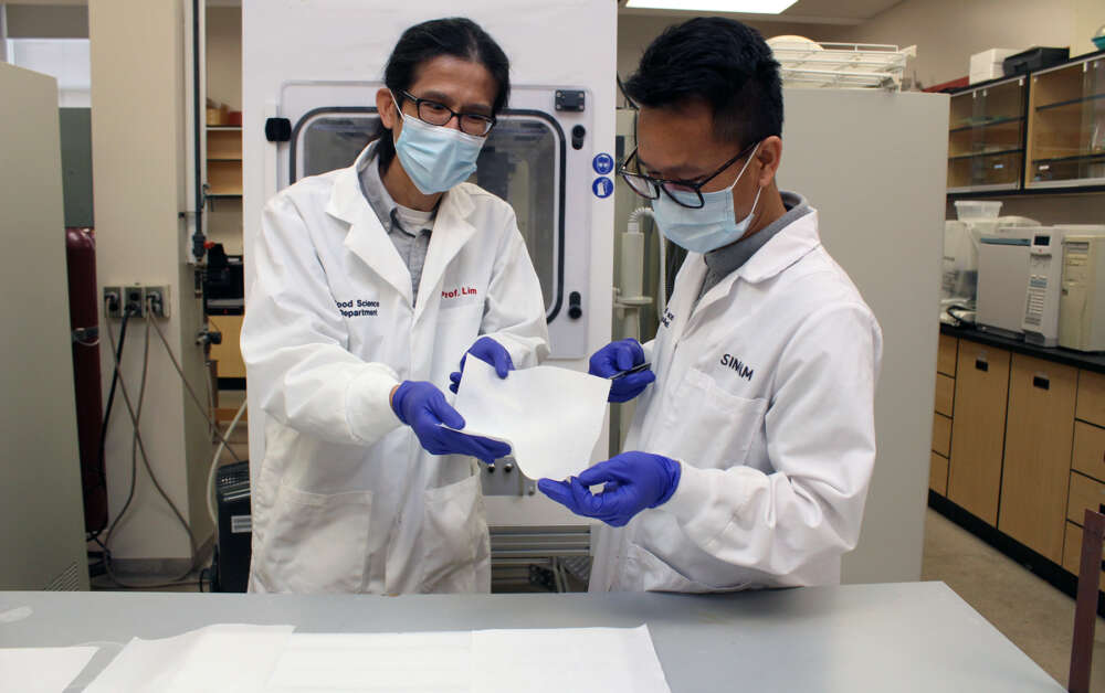Food science professor Dr. Loong-Tak Lim (left) and graduate student Singam Suranjoy Singh display the mask filter material
