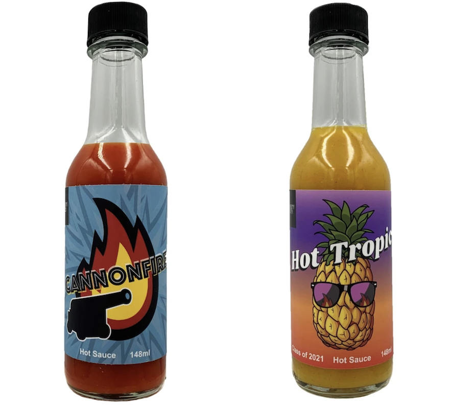 Two small bottles of hot sauce, one labelled Cannonfire, the other Hot Tropic