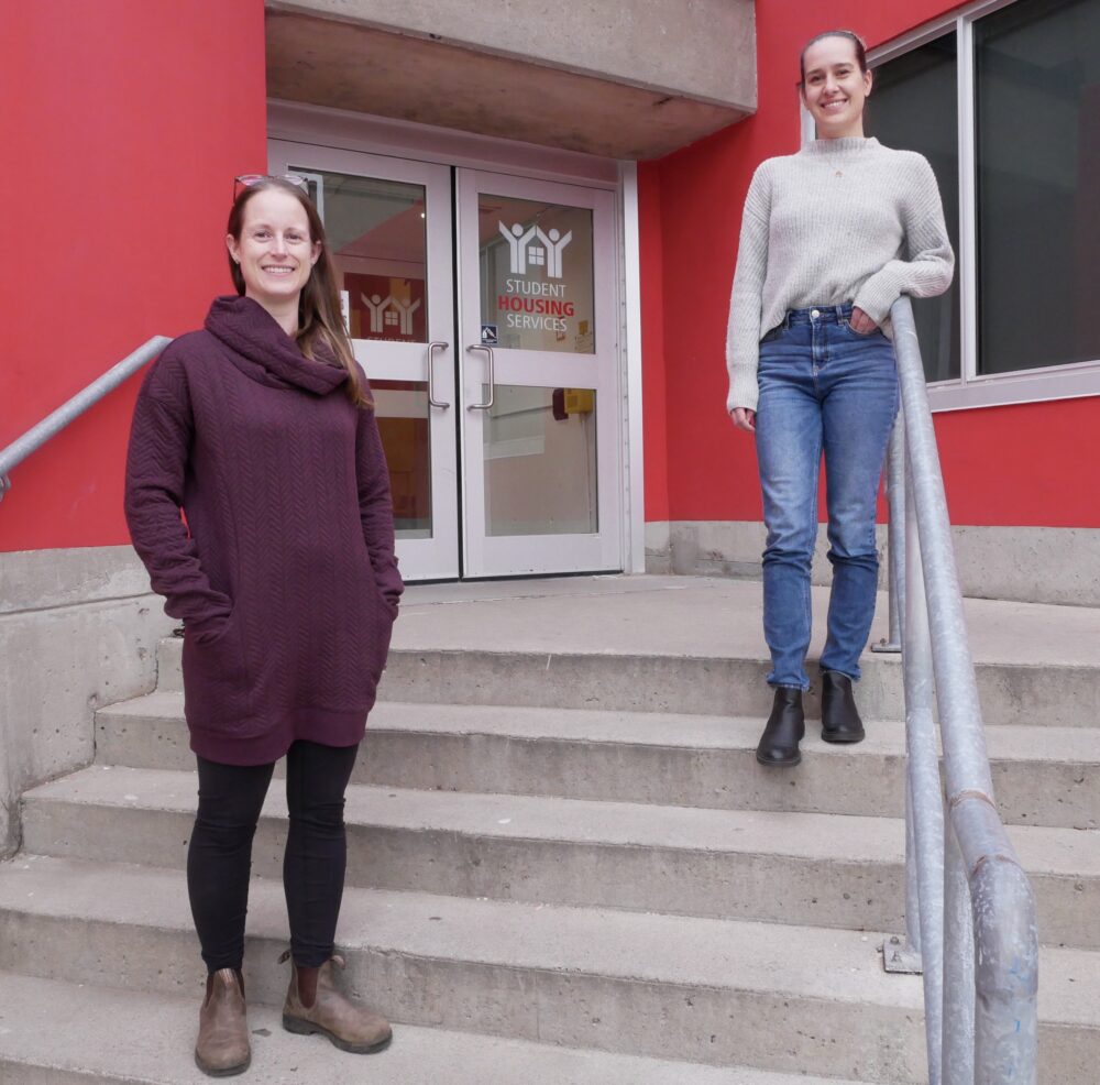 Two women social distanced on stairs to U of G building