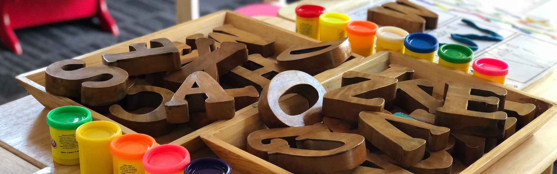 A low table with play-doh containers and block letters
