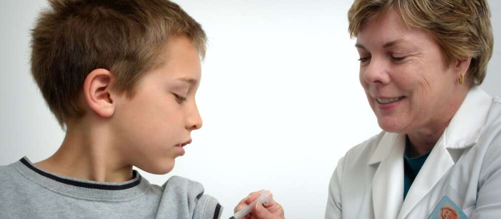 woman inject boy on arm