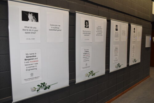 image of white posters with text and photos of the women killed in the Dec. 6 massacre hang in a row along a grey brick wall