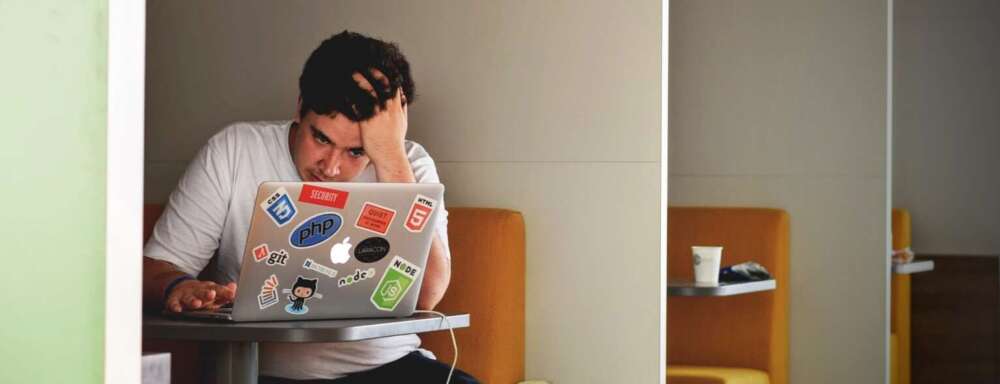 Man wearing white top using MacBook