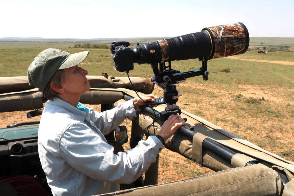 Roberta Bondar on safari looks at the display on a camera with a telephoto lens