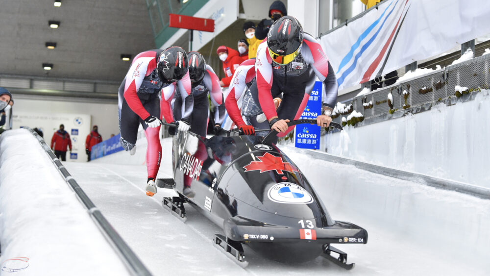 Members of Team Canada's four-men bobsleigh start on the track.