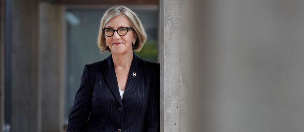 Dr. Charlotte Yates leans against a concrete wall
