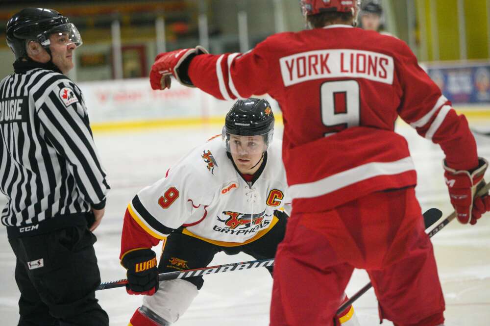 Mikkel Aagaard in a face-off during an ice hockey game against York University.