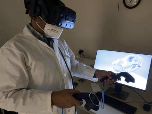 man wearing virtual reality goggles before a computer screen