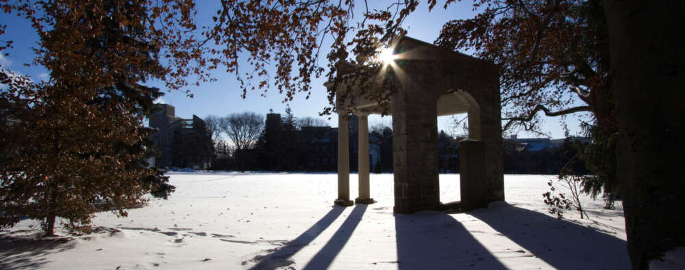 A silhouette of the portico on the U of G campus in winter as the sun sets behind it