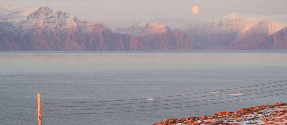 Landscape photo of the sun setting over Pond Inlet (Mittimatalik)