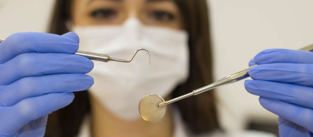 woman in white shirt holding blue plastic spoon