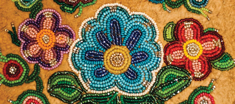 A closeup of moccasin beadwork showing flowers and vines