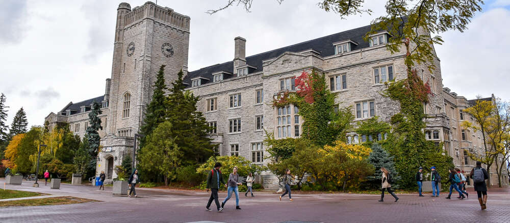 Students walk across U of G campus in front of Johnston Hall.