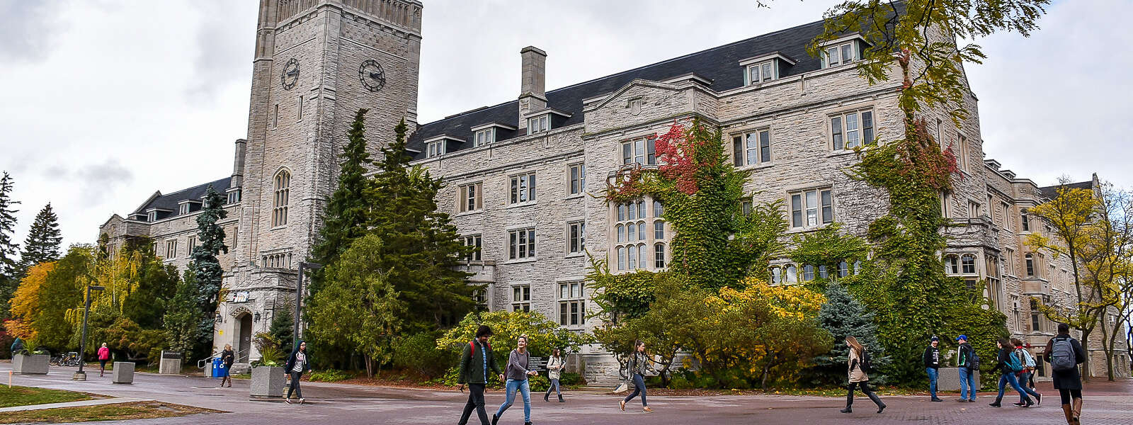 Students walk across U of G campus in front of Johnston Hall.