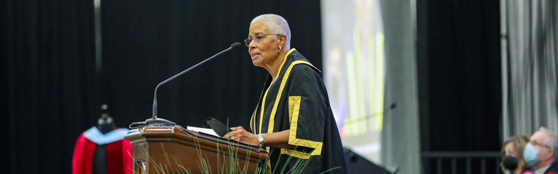Dr. Mary Anne Chambers stands at podium speaking at 2022 convocation.