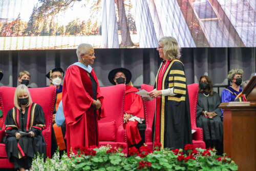 Dr. Mary Anne Chambers stands onstage with U of G president Dr. Charlotte Yates.
