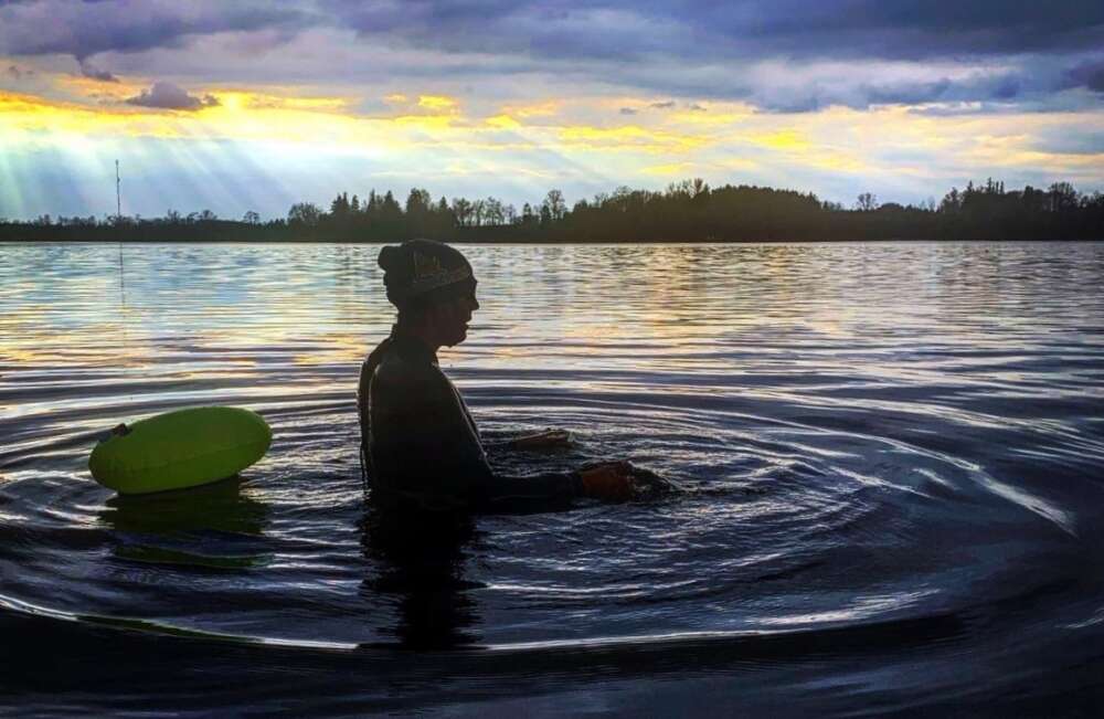 Coralee Allaert swims in a lake at sunset.