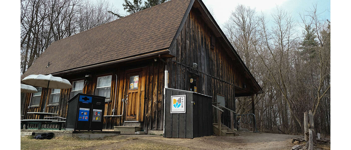 The exterior of the J.C. Taylor Nature Centre building with a rainwater harvesting system within a wooden shed o n the corner of the building