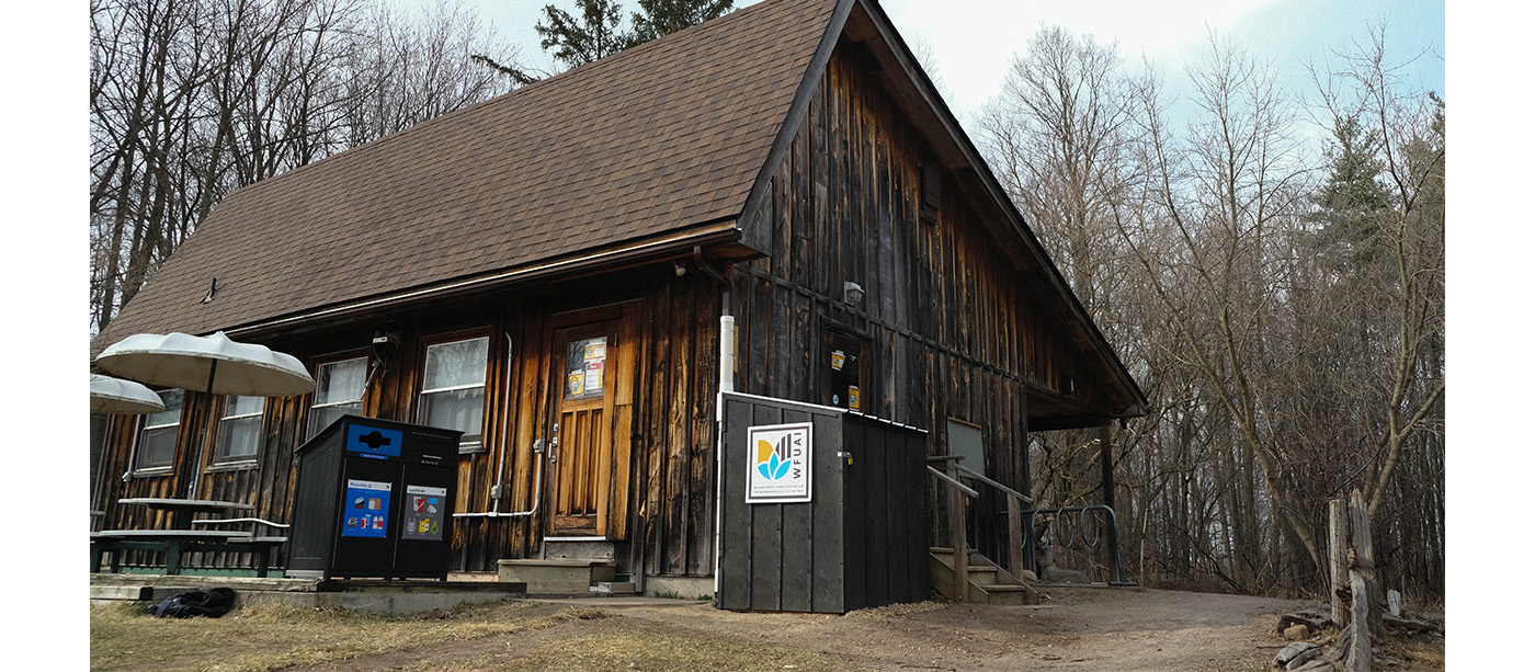 The exterior of the J.C. Taylor Nature Centre building with a rainwater harvesting system within a wooden shed o n the corner of the building