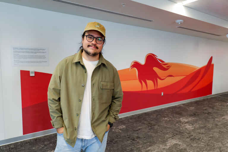 Artist Luke Swinson in front of new mural