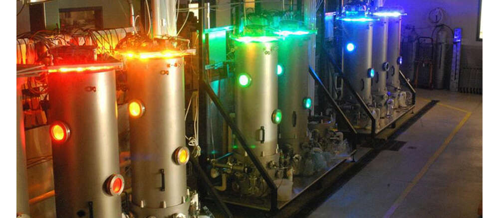 large stainless steel vats each let a different colour of the rainbow