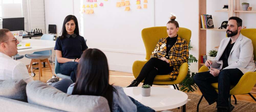 People seated around a table in a meeting room.