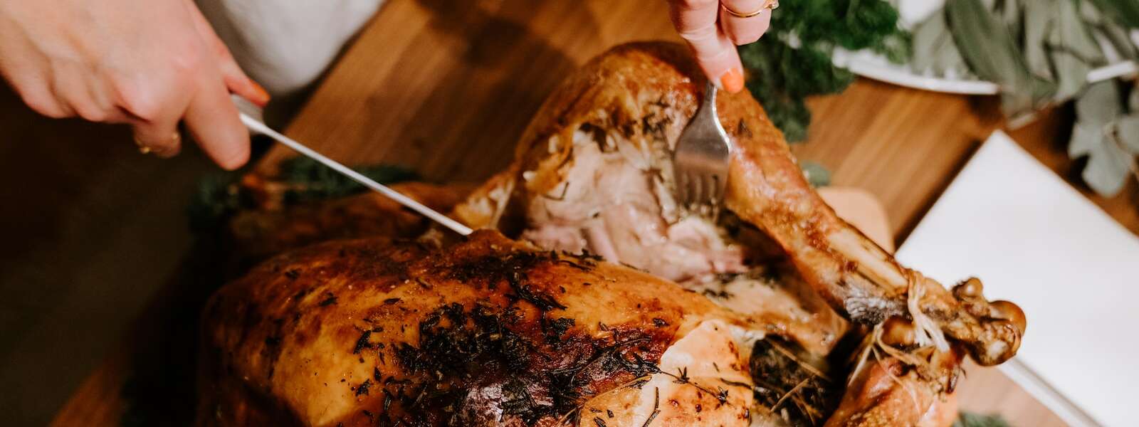 A person carves into a turkey.